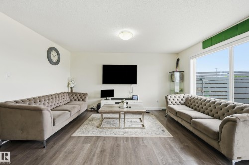 Spacious interior with wood-finish flooring, white walls, and a large window - 941 Ebbers Crescent Nw, Edmonton, AB 