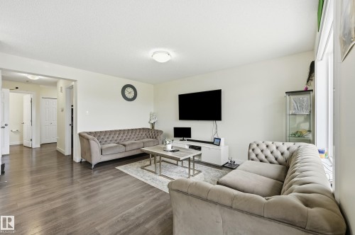 Spacious living area featuring wood-finish flooring, light-colored walls, and a ceiling-mounted light fixture - 941 Ebbers Crescent Nw, Edmonton, AB 