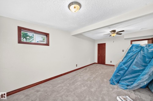 Carpeted room with white walls, a wood-trimmed window, and dark wood baseboards - 9719 71 Avenue Nw, Edmonton, AB - Indoor Photo Showing Other Room