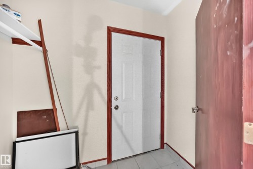 White paneled interior door with wood-finish trim, set within a neutral-toned wall space - 9719 71 Avenue Nw, Edmonton, AB - Indoor Photo Showing Other Room