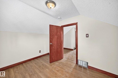 Room featuring wood-finish flooring, white walls, and a textured ceiling - 9719 71 Avenue Nw, Edmonton, AB - Indoor Photo Showing Other Room