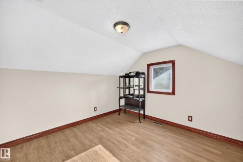 Versatile room with sloped ceilings and light beige walls - 9719 71 Avenue Nw, Edmonton, AB - Indoor Photo Showing Other Room
