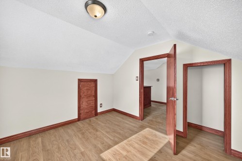 Room featuring wood-finish flooring, light-colored walls, and a textured ceiling - 9719 71 Avenue Nw, Edmonton, AB - Indoor Photo Showing Other Room