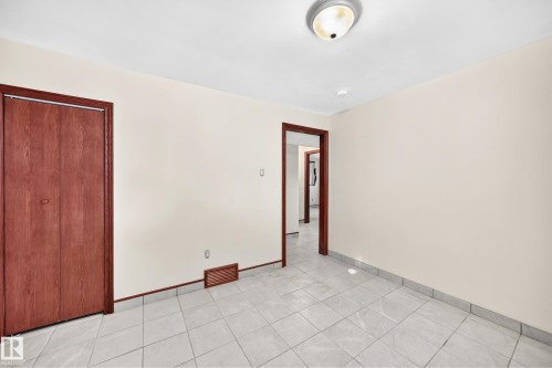 Neutral wall finishes complement the light-toned tile flooring - 9719 71 Avenue Nw, Edmonton, AB - Indoor Photo Showing Other Room