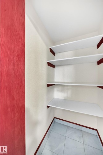 Built-in shelving unit with white shelves and contrasting dark wood supports - 9719 71 Avenue Nw, Edmonton, AB - Indoor With Storage