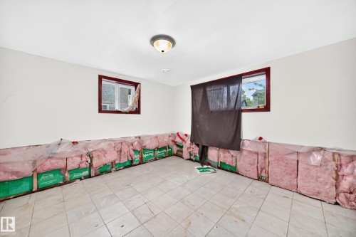 Interior space featuring a tiled floor, white painted walls, and two windows with dark wood trim - 9719 71 Avenue Nw, Edmonton, AB - Indoor