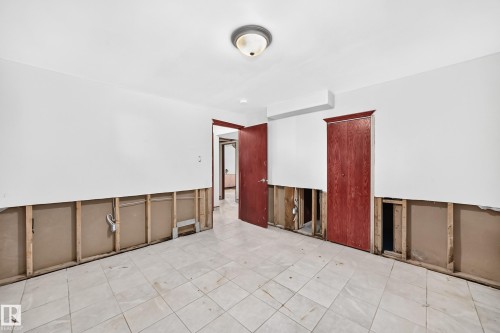 Room featuring white walls, a tiled floor, and two dark wood-finish doors - 9719 71 Avenue Nw, Edmonton, AB - Indoor Photo Showing Other Room