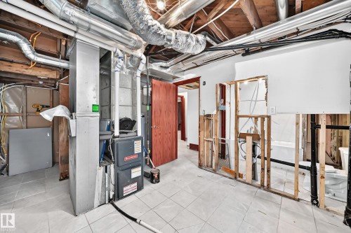 Utility room featuring exposed ceiling joists, overhead ductwork, and a Goodman furnace unit - 9719 71 Avenue Nw, Edmonton, AB - Indoor Photo Showing Basement
