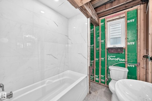 White subway tile tub surround, recessed lighting, white built-in tub, and unfinished construction elements - 9719 71 Avenue Nw, Edmonton, AB - Indoor Photo Showing Bathroom