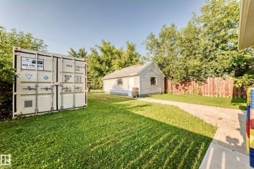 Expansive green space featuring a detached building, concrete path, and privacy fencing - 9719 71 Avenue Nw, Edmonton, AB - Outdoor
