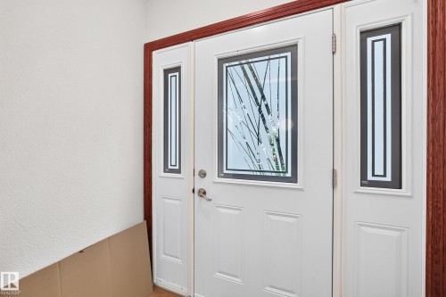 White entry door with decorative glass inserts and coordinating sidelights - 9719 71 Avenue Nw, Edmonton, AB - Indoor Photo Showing Other Room