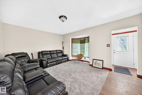 Open-concept living area featuring light neutral walls and gray carpeting - 9719 71 Avenue Nw, Edmonton, AB - Indoor Photo Showing Living Room