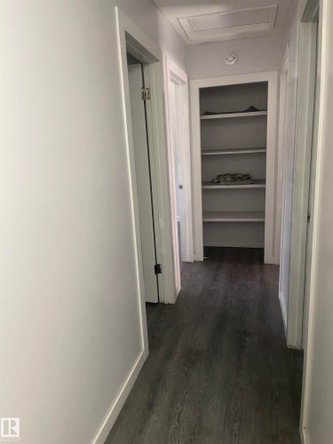 Wood-finish flooring throughout, white trim, and built-in shelving - 3221 132A Avenue Nw, Edmonton, AB 