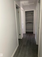 Wood-finish flooring throughout, white trim, and built-in shelving - 
