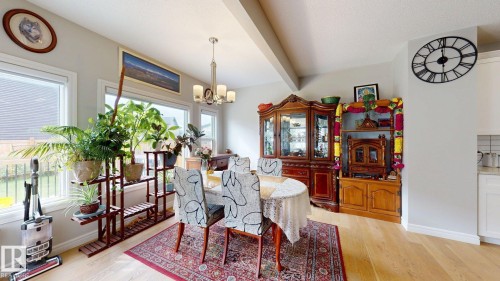 Light wood-finish flooring, multiple pane windows, and a chrome chandelier - 22407 99 Avenue Nw, Edmonton, AB 