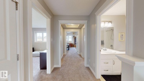 Hallway with neutral carpeting, white trim, and light gray walls - 22407 99 Avenue Nw, Edmonton, AB 