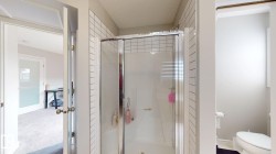 Shower enclosure with clear glass doors and white subway tile surround - 