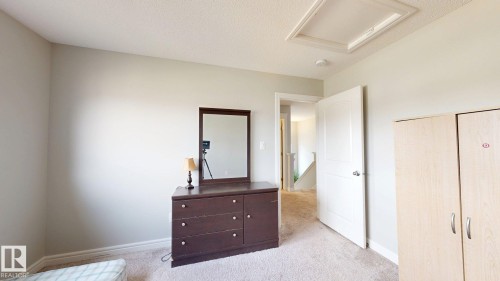 Light-colored carpeting, white interior doors with contemporary hardware, and a textured ceiling - 22407 99 Avenue Nw, Edmonton, AB 