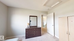 Light-colored carpeting, white interior doors with contemporary hardware, and a textured ceiling - 