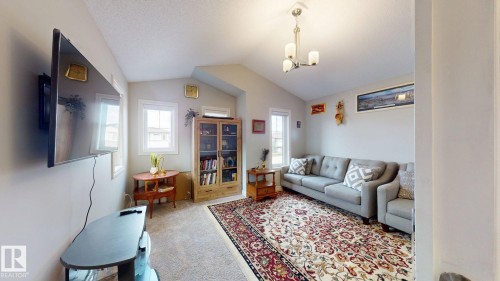 Vaulted ceiling with a chandelier, carpet flooring, and multiple windows providing natural light - 22407 99 Avenue Nw, Edmonton, AB 