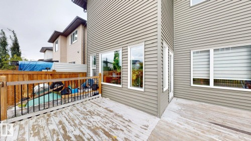 Wood deck surface, wood privacy fence, multi-pane windows, tan horizontal siding, white trim - 22407 99 Avenue Nw, Edmonton, AB 