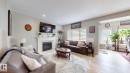 Living area featuring a fireplace with a white mantel, recessed lighting, and wood-finish flooring - 22407 99 Avenue Nw, Edmonton, AB 