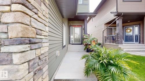 Stone veneer column, horizontal siding, covered entryway, concrete walkway, and landscaped planting - 22407 99 Avenue Nw, Edmonton, AB 