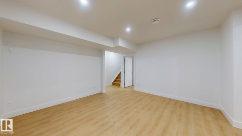 Spacious interior with neutral white walls, recessed ceiling lighting, and wood-finish flooring - 22407 99 Avenue Nw, Edmonton, AB 