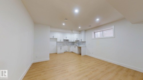 Open-concept living space featuring wood-finish flooring, recessed lighting, white cabinetry, and a window with blinds - 22407 99 Avenue Nw, Edmonton, AB 