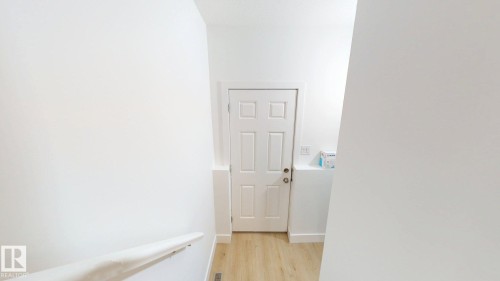 White paneled interior door with light wood-finish flooring - 22407 99 Avenue Nw, Edmonton, AB 