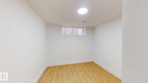Recessed ceiling lighting with a round fixture, wood-finish flooring, and a window with horizontal blinds - 22407 99 Avenue Nw, Edmonton, AB 