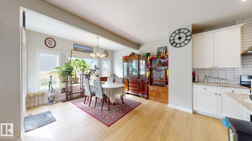 Light wood-finish flooring, white cabinetry, light countertops, subway tile backsplash, and recessed lighting - 22407 99 Avenue Nw, Edmonton, AB 