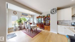 Light wood-finish flooring, white cabinetry, light countertops, subway tile backsplash, and recessed lighting - 