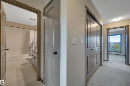 Hallway featuring neutral-toned walls, carpeted flooring, and paneled doors - 12903 205 Street Nw, Edmonton, AB 