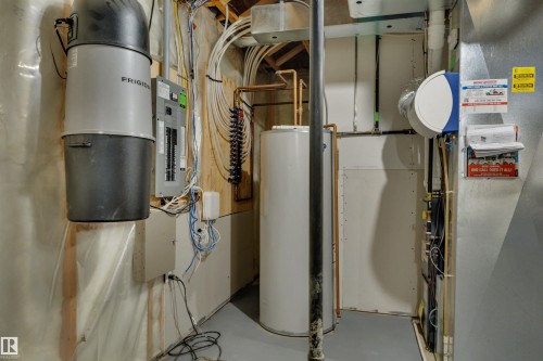 Central vacuum system, electrical panel, hot water heater, exposed copper piping, and ductwork - 12903 205 Street Nw, Edmonton, AB 