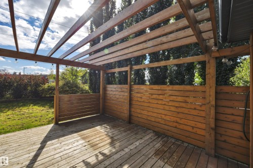 Expansive wooden deck featuring a slatted pergola, privacy screen walls, and string lighting - 12903 205 Street Nw, Edmonton, AB 