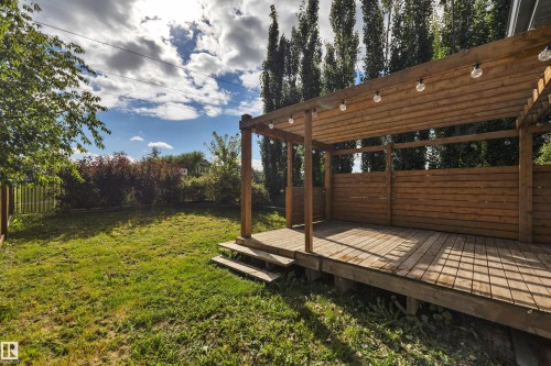 Expansive backyard featuring a wood deck with a pergola, integrated string lighting, and wood privacy screens - 12903 205 Street Nw, Edmonton, AB 