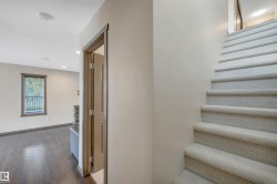 Carpeted staircase, wood-finish flooring, recessed lighting, and a window with blinds - 