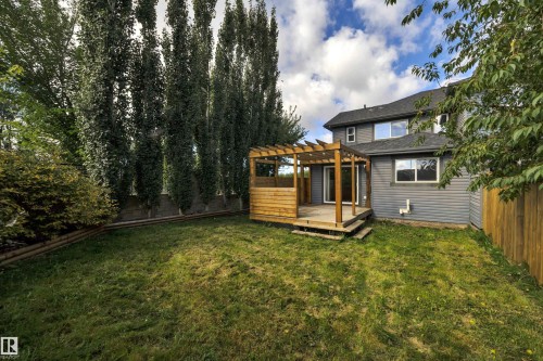 Expansive lawn with a wood deck, pergola, and exterior siding - 12903 205 Street Nw, Edmonton, AB 