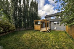 Expansive lawn with a wood deck, pergola, and exterior siding - 