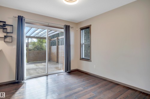 Wood-finish flooring, sliding glass patio door, exterior wood deck, and a single window with blinds - 12903 205 Street Nw, Edmonton, AB 