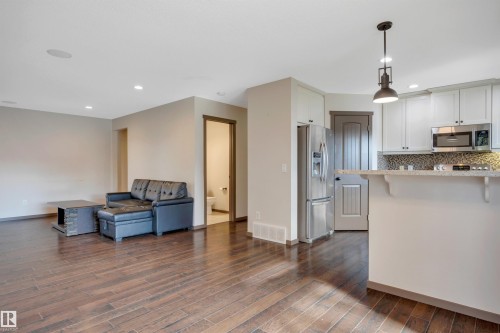 Wood-finish flooring, recessed lighting, white cabinetry, stainless steel appliances, and tiled backsplash - 12903 205 Street Nw, Edmonton, AB 