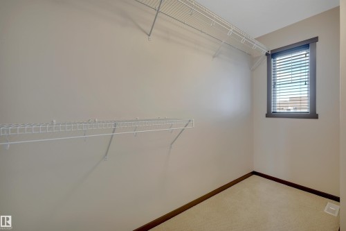 Integrated wire shelving system, neutral wall paint, window with blinds, carpeted flooring - 12903 205 Street Nw, Edmonton, AB 