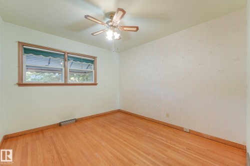 Hardwood flooring, wood trim window frame, textured wall finish, and a ceiling fan with integrated lighting - 11507 135 Street Nw, Edmonton, AB 
