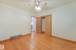 Hardwood flooring, wood-finish baseboards, and a ceiling fan with integrated lighting - 