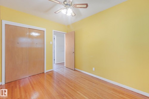 Hardwood flooring, wood closet doors, ceiling fan with integrated lighting, and a solid core interior door - 11507 135 Street Nw, Edmonton, AB 