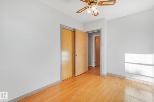 Wood-finish flooring, light grey wall paint, and a ceiling fan with integrated lighting - 11507 135 Street Nw, Edmonton, AB 