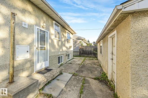 Stucco exterior with multiple windows and a storm door - 11507 135 Street Nw, Edmonton, AB 