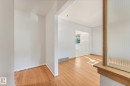 Hardwood flooring throughout, white painted walls, and a wood-framed privacy screen - 11507 135 Street Nw, Edmonton, AB 