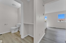 Neutral color palette, wood-finish flooring, white trim, recessed lighting, and a window providing natural light - 